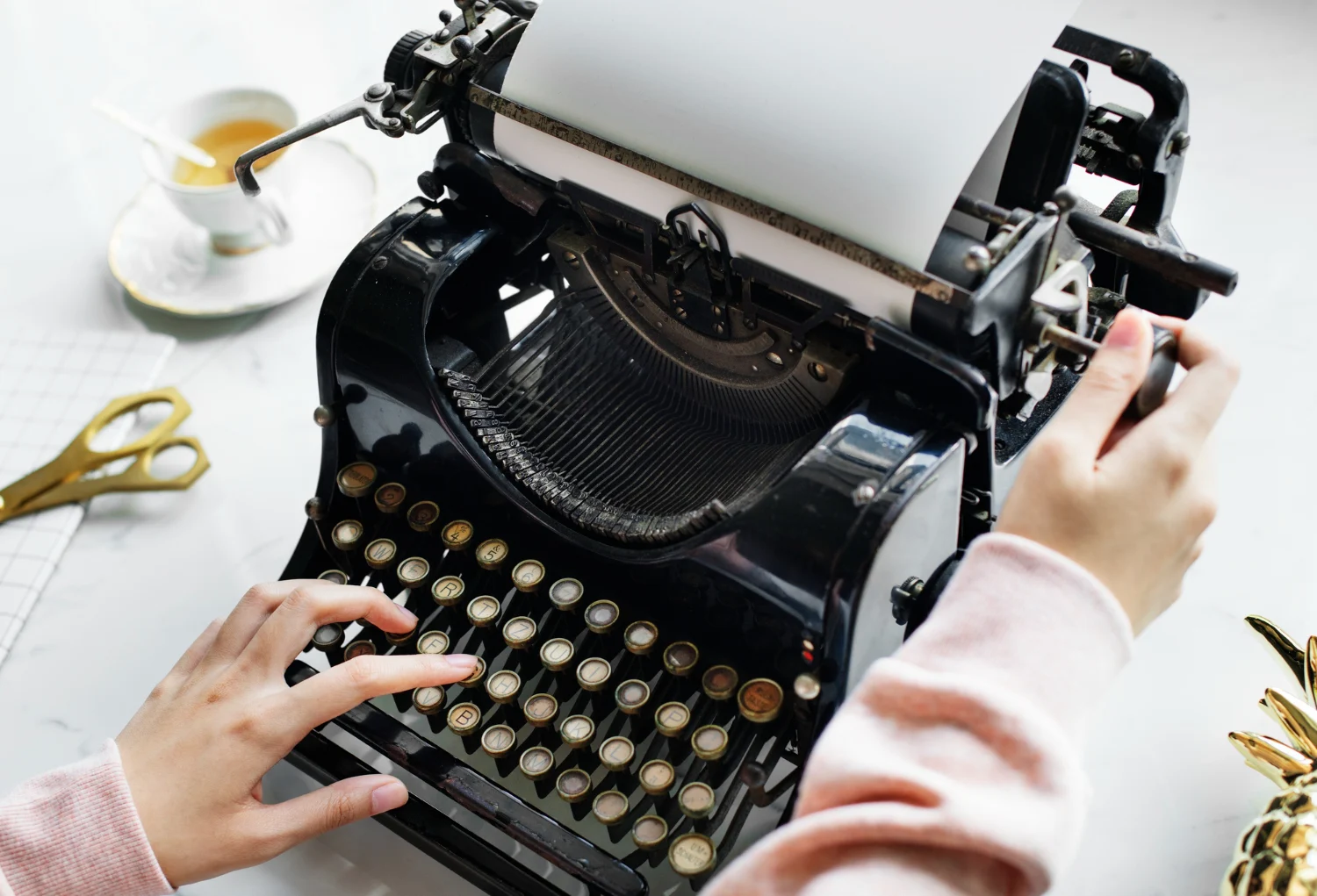 An old fashioned type writer showing hands typing.