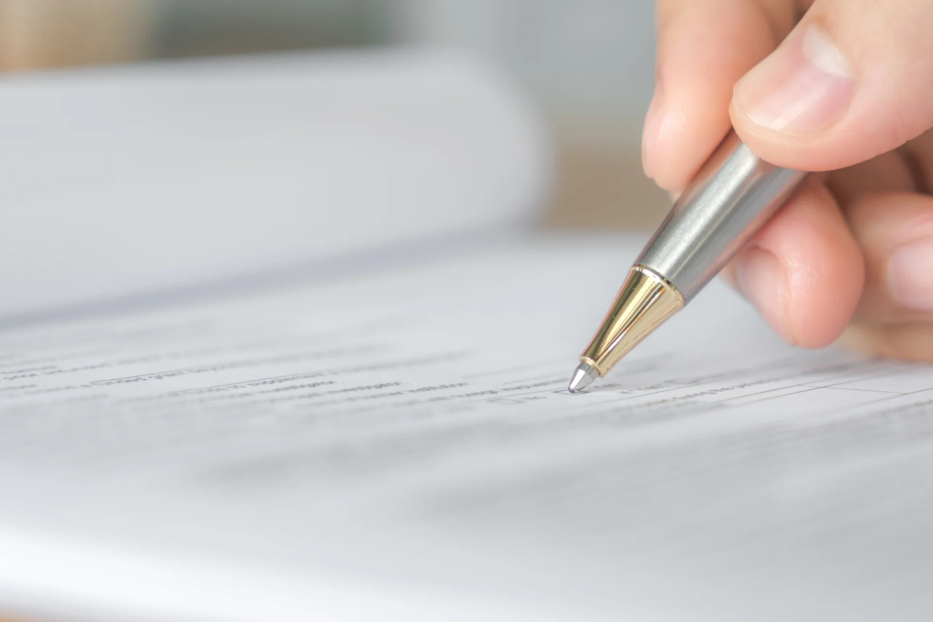 A pen resting on someone's will, ready to sign. They have wanted to exclue someone from their will and taking professional advice.