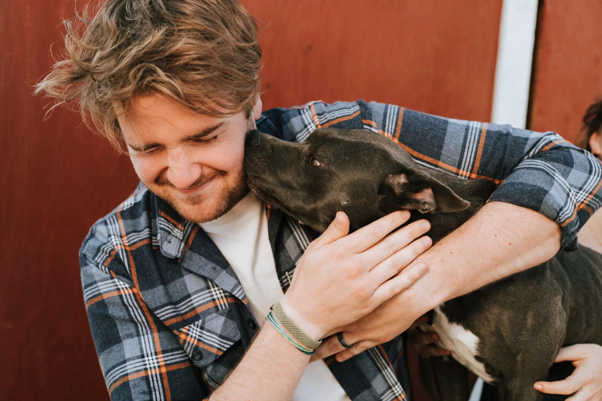 A lovely black dog is snuggling into their owners cheek. The owner has written a will to ensure their dog is looked after.
