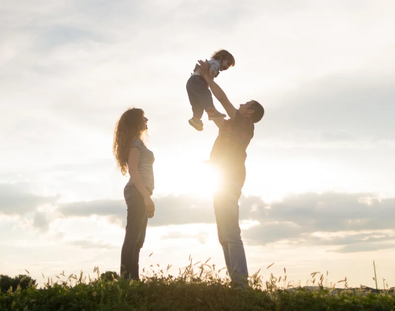 A couple playing with their child with happiness having written their will.